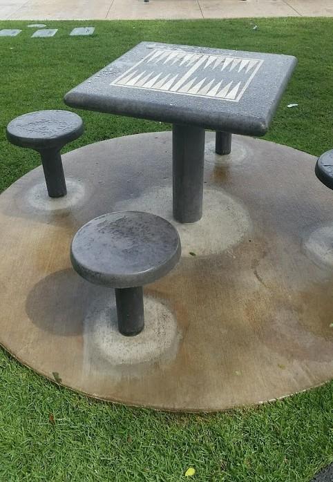 Direct Burial Concrete Backgammon Table for Permanent Outdoor Installation Direct burial concrete backgammon table installed in a park with tropical landscape.